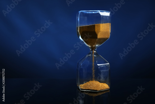 Hourglass on color dark background. Time management concept