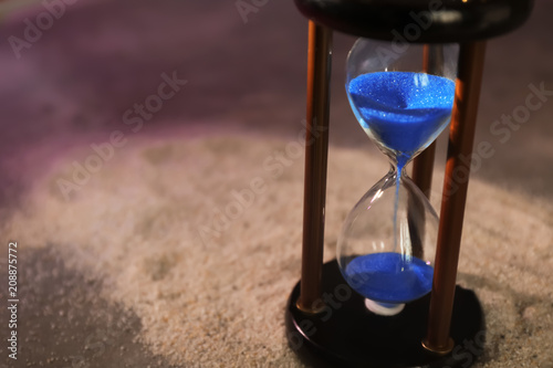 Hourglass on sand. Time management concept © Pixel-Shot