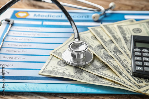 Stethoscope with money and calculator on medical record. Health care concept