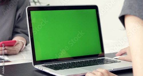 Asian Female Office Employee at Her Desktop Works on a Mock-up Green Screen Laptop. Over the Shoulder Footage. Creative Office Evening.Dolly left to right 