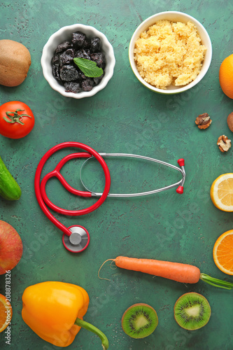 Healthy food with stethoscope on color background