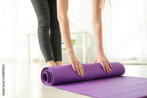 Morning of beautiful young woman with yoga mat going to training at home, closeup