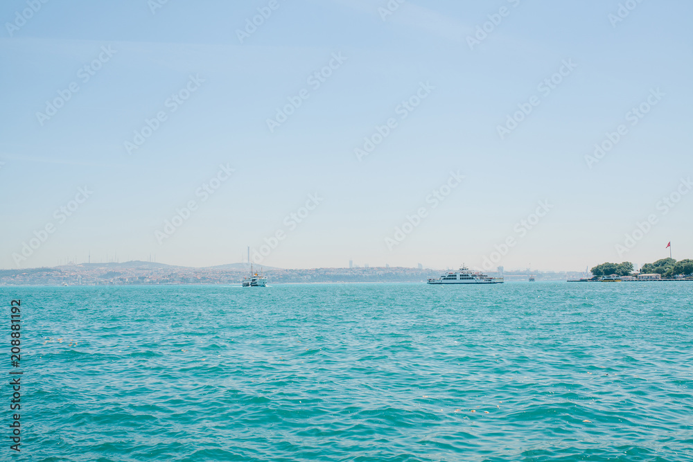A ship or a passenger liner sails along the Bosphorus in Istanbul. Urban architecture in the background A ship or a passenger liner sails along the Bosphorus in Istanbul. Urban architecture in the background