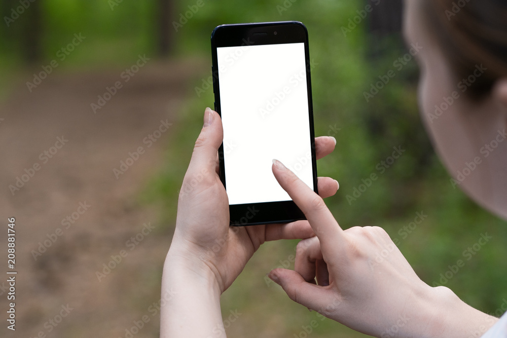 girl in the park enjoys navigation in the smartphone