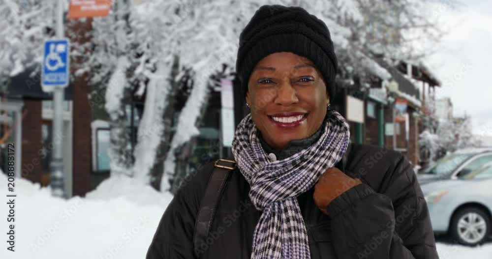 Portrait of cute senior woman standing on snowy street, Happy grandmother enjoying cold winter day outside, 4k