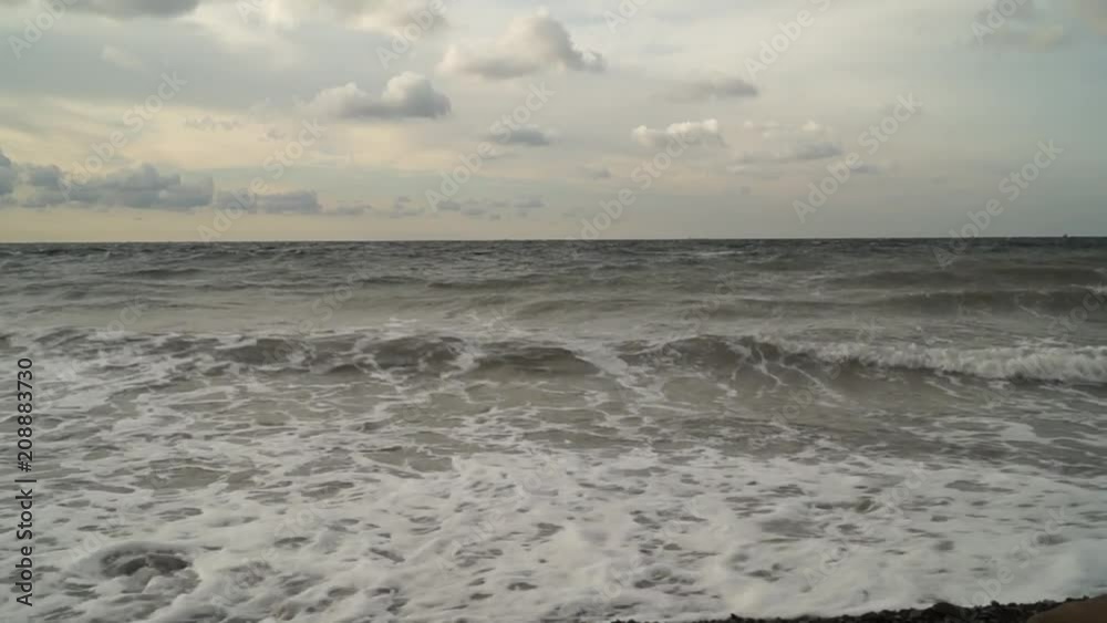 The sea with small waves near the shore in the early morning before dawn in cloudy weather. The sea with small waves near the shore in the early morning before dawn in cloudy weather.