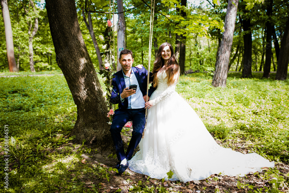 Cute couple walking in the forest near a swing with a decor