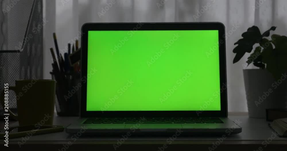 Laptop with green screen. Dark office. Dolly in. Perfect to put your own image or video. Laptop with green screen. Dark office. Dolly in. Perfect to put your own image or video.