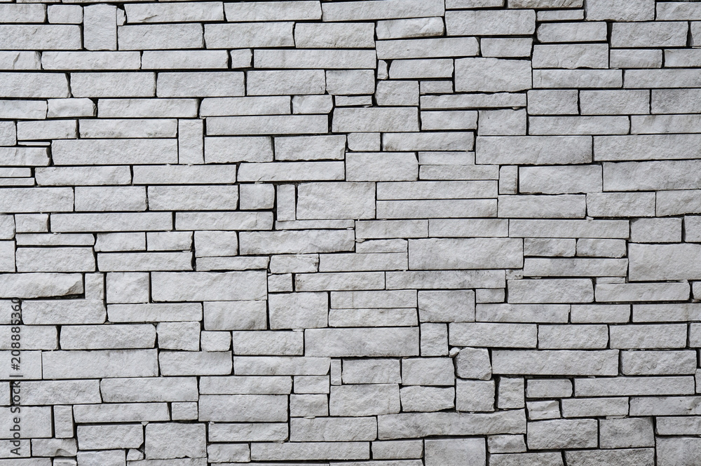 Obraz premium White wall built using irregular cuts bricks