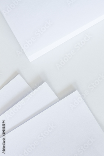 White paper and notepad on white desk