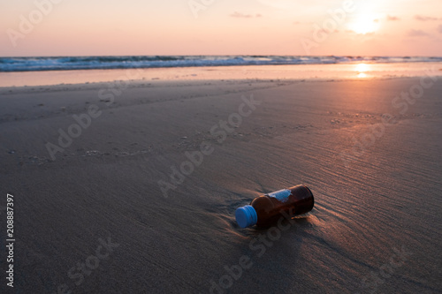 Glass bottles is dump into the sea, dirty waste on beach in summer day