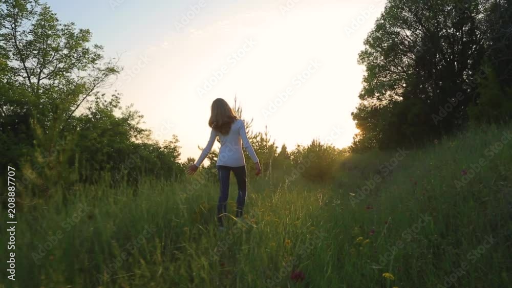 Girl walking on a hillside with wheat. Scenic view. Smooth motion of the camera Girl walking on a hillside with wheat. Scenic view. Smooth motion of the camera