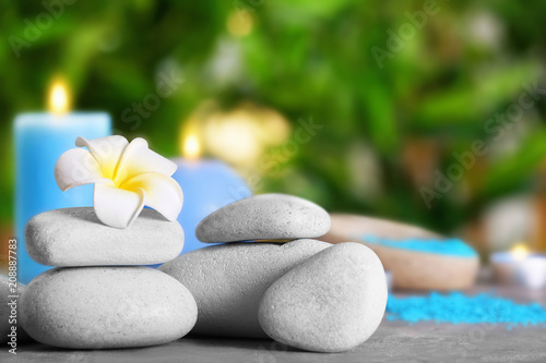 Spa stones with beautiful flower on table outdoors