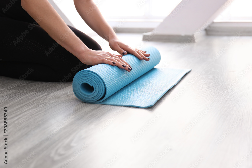 Fototapeta premium Young woman with yoga mat indoors