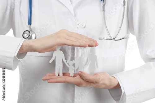 Female doctor with family figure on white background, closeup © Pixel-Shot