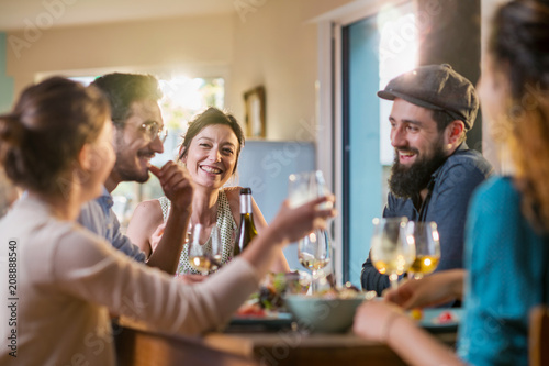 Mixed group of friends having fun while sharing a meal 