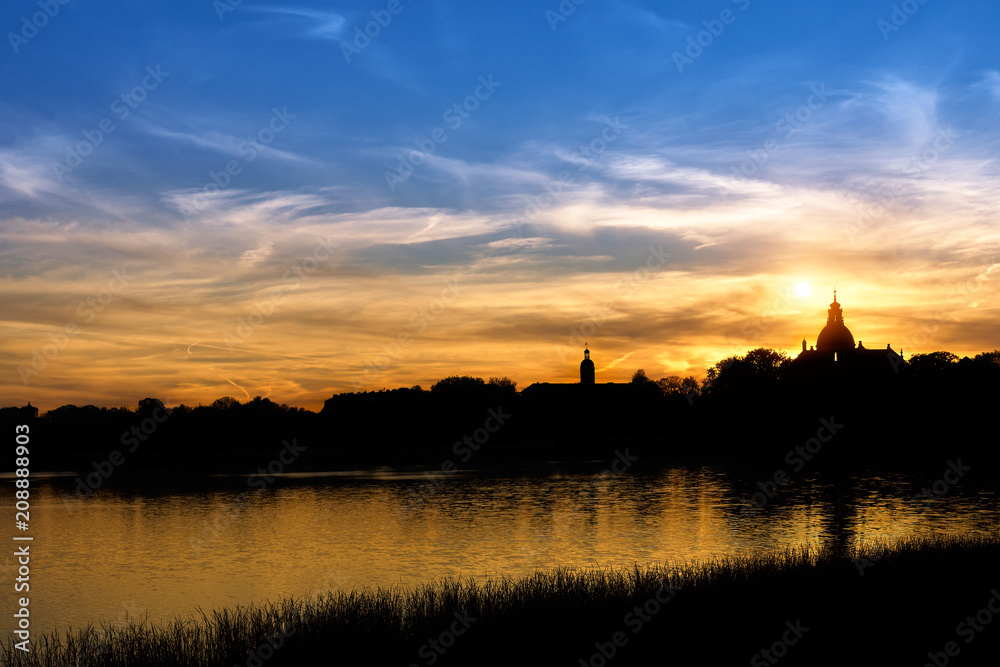 silhouette of the castle near the lake on sunset background