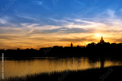 silhouette of the castle near the lake on sunset background