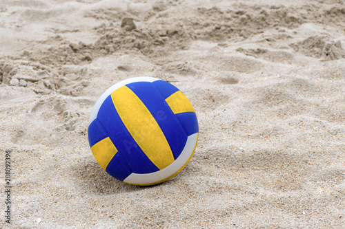 Blue and Yellow Volleyball on the beach and footprint on the sands