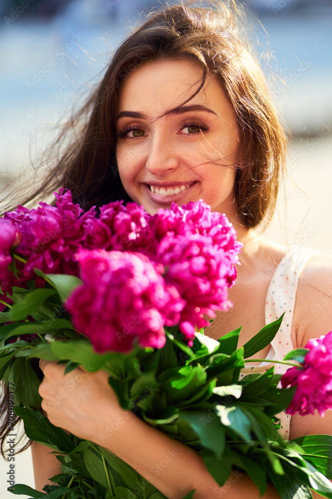 Spring / Summer Style. Beautiful Young Brunette Woman In A Nice Spring Dress With A Bouquet Of Pions. Beautiful Spring Street. Fashion Spring Summer Photo. Spring / Summer Style. Beautiful Young Brunette Woman In A Nice Spring Dress With A Bouquet Of Pions. Beautiful Spring Street. Fashion Spring Summer Photo.