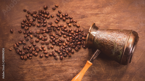 Vintage cezve. coffey grains on a wooden background. toned