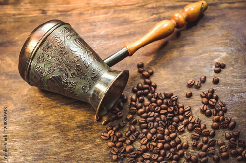 Vintage cezve. coffey grains on a wooden background. toned