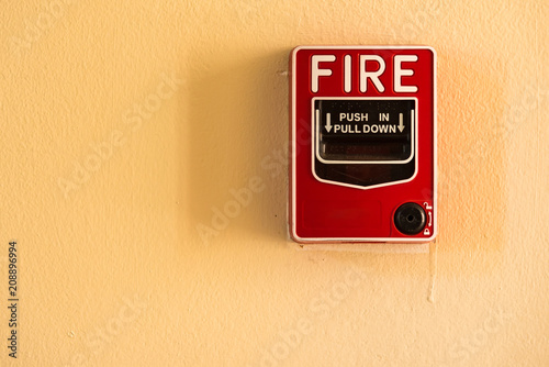 Fire break glass alarm switch on the cement wall.