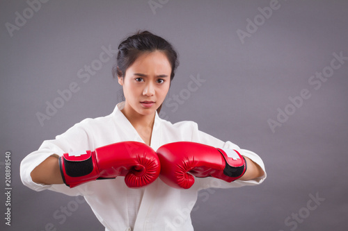 woman fighter portrait; asian woman practicing martial arts, mixed martial arts, MMA, karate, gongfu studio isolated portrait; girl fighter training concept; 20s young adult asian woman model