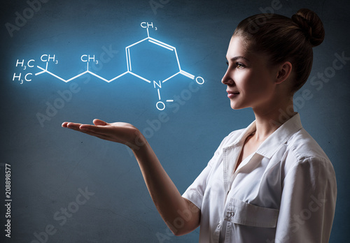 Young female doctor presents chemical formula. photo