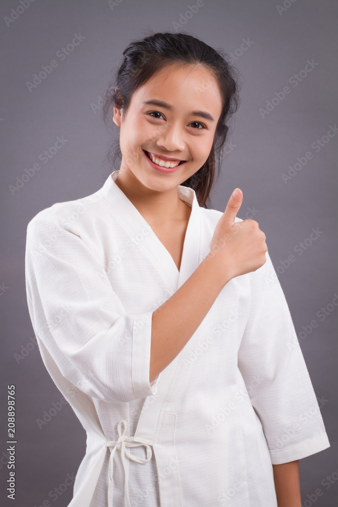 woman spa therapist pointing thumb up; asian woman spa therapist, spa worker, aesthetics girl staff pointing approval thumb up; good esthetics or cosmetics service concept; 20s adult asian woman model woman spa therapist pointing thumb up; asian woman spa therapist, spa worker, aesthetics girl staff pointing approval thumb up; good esthetics or cosmetics service concept; 20s adult asian woman model