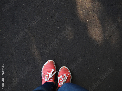 a pair of pink sneakers on the wet asphalt