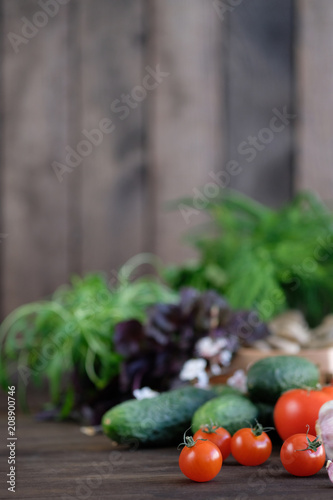 Vegetable.Fresh vegetables: tomatos, cucumbers,peppers,onions and green seasonings on  old rustic oak table. © Soyka