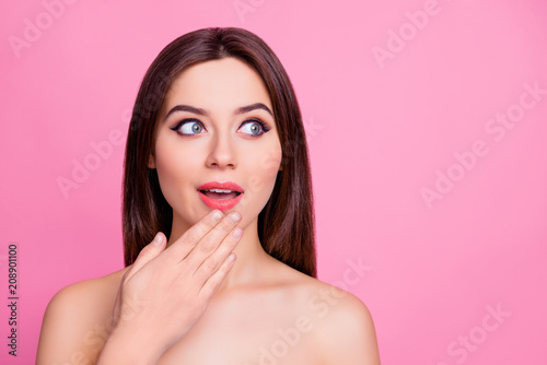 Wow  Portrait of wondered impressed beautiful attractive cute lovely woman is touching her chin looking up on empty blank copy space  isolated on pink background