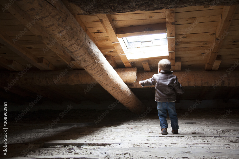 Fototapeta premium little boy playing in the loft of an old house