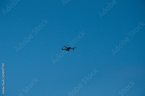 Black quadrupter with propellers flies in the sky and photographs landscapes