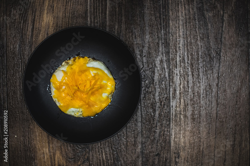 From the top view of fried eggs and cheese in a black plate