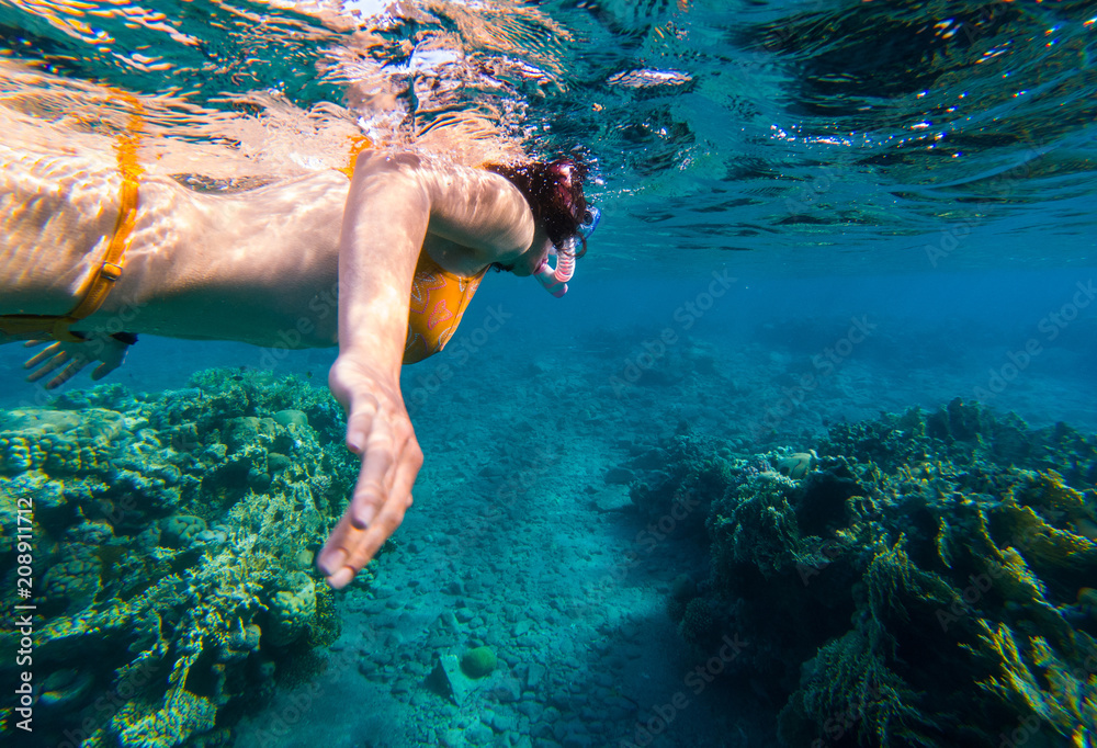 Woman snorkeling above coral reef