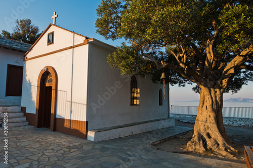 Fotografie Olive tree and the church of Agios Ioannis Kastri at sunset, famous from Mamma M
