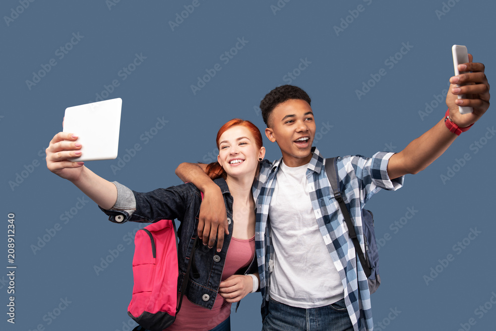 Obraz premium Our selfie. Happy nice man hugging his girlfriend while taking a selfie with her