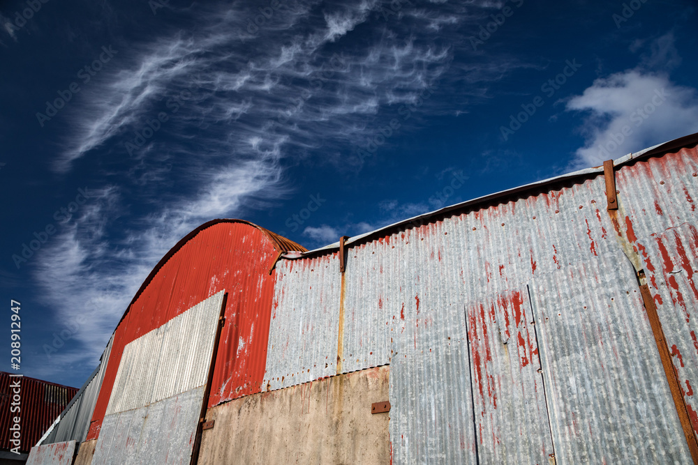old corrugated iron farmland barn structure, blue sky background old corrugated iron farmland barn structure, blue sky background