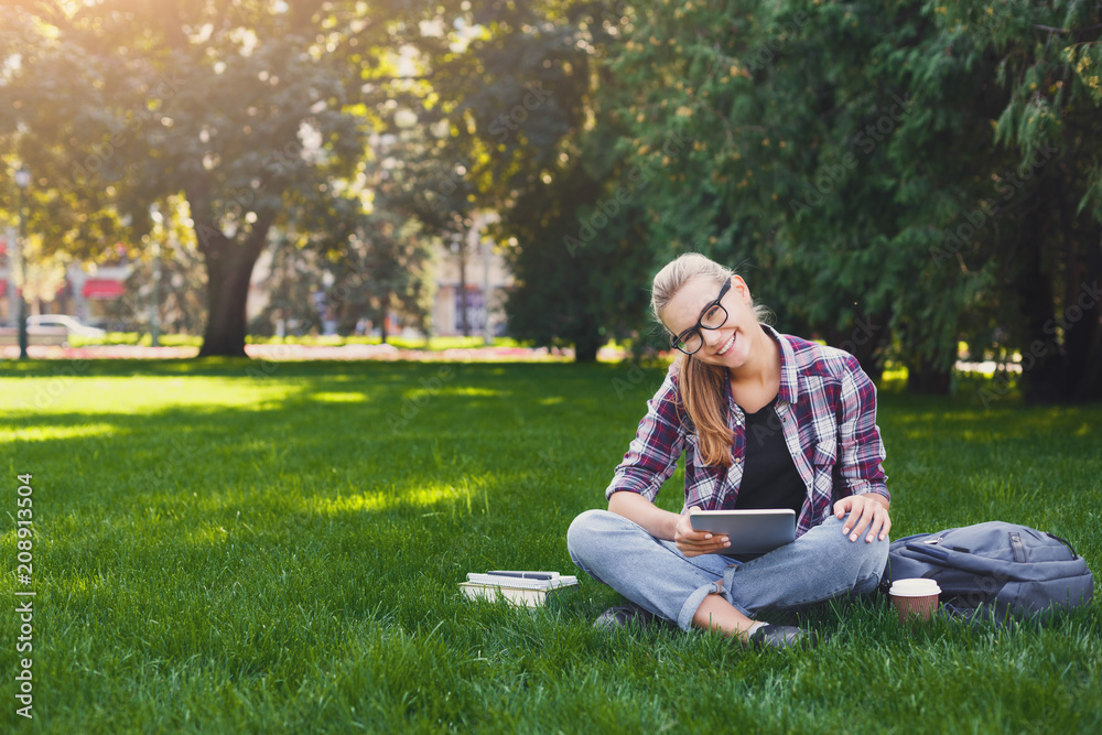Happy young woman using digital tablet in park Happy young woman using digital tablet in park