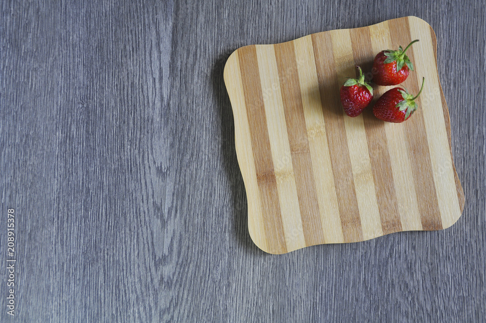 Red strawberries on cutting Board on wooden table 