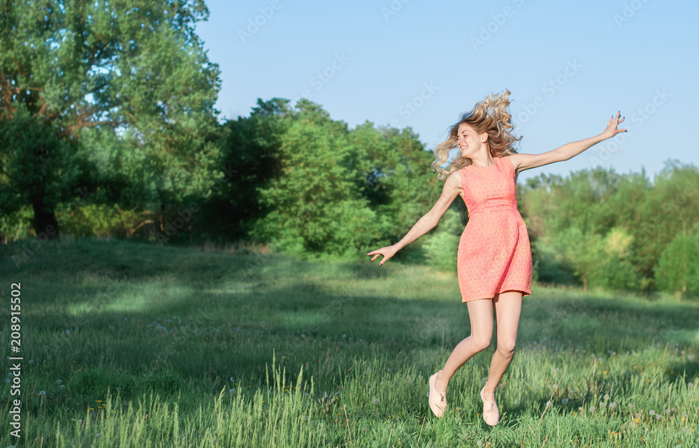 Pretty young woman jumping on green grass Pretty young woman jumping on green grass