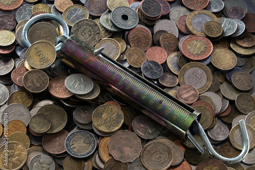steelyard on a pile of various coins