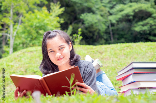 Outdoor portrait of a cute young girl reading a book - Asia people