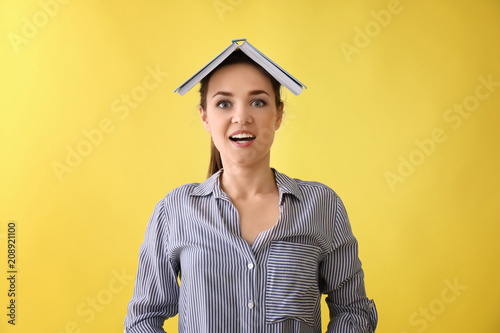 Funny young woman with book...