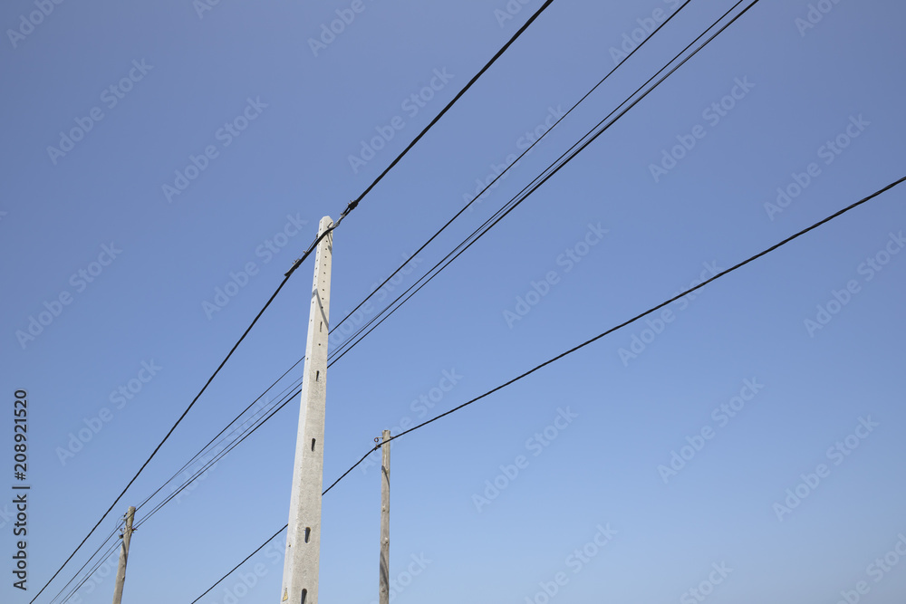 Three electricity poles and lines against a blue sky Three electricity poles and lines against a blue sky