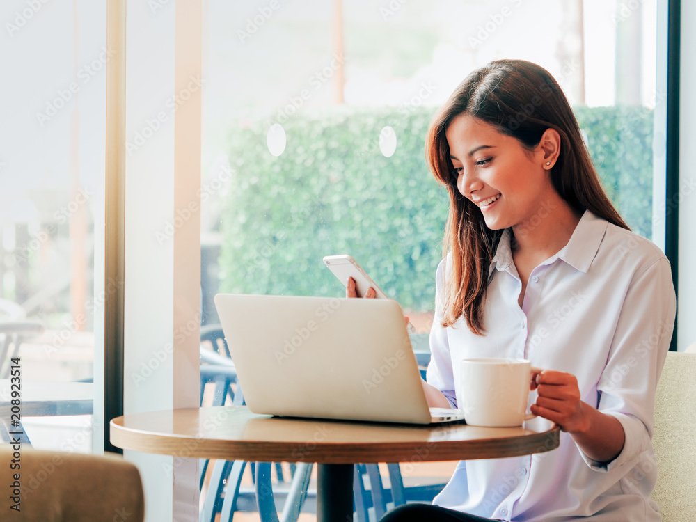 Asain woman working with laptop in coffee shop. Asain woman working with laptop in coffee shop.