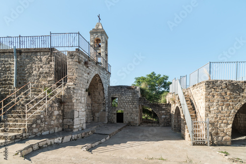 The fasade with the belfry of the functioning church of the Christian Maronites in the abandoned village Kafr Birim in the north of Israel photo
