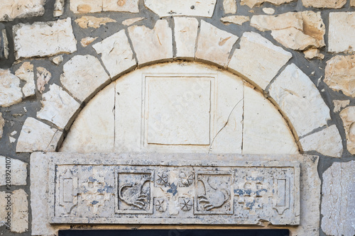 Decorative carvings over the stone in the course of the church of the Christian Maronites in the abandoned village Kafr Birim in the north of Israel photo